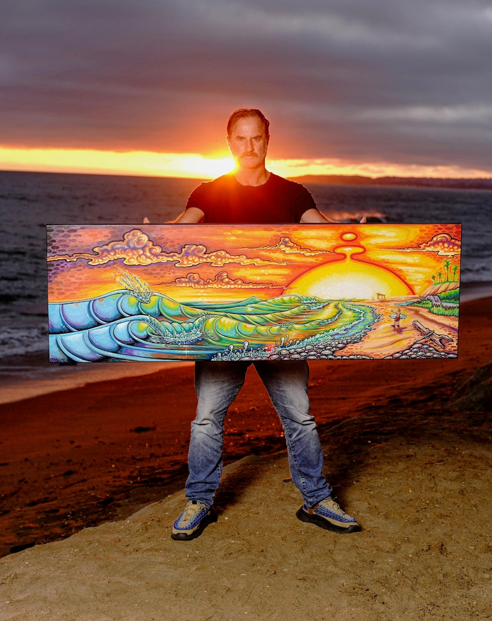 Drew Brophy holding a his Trestles Painting of the shore of Trestles